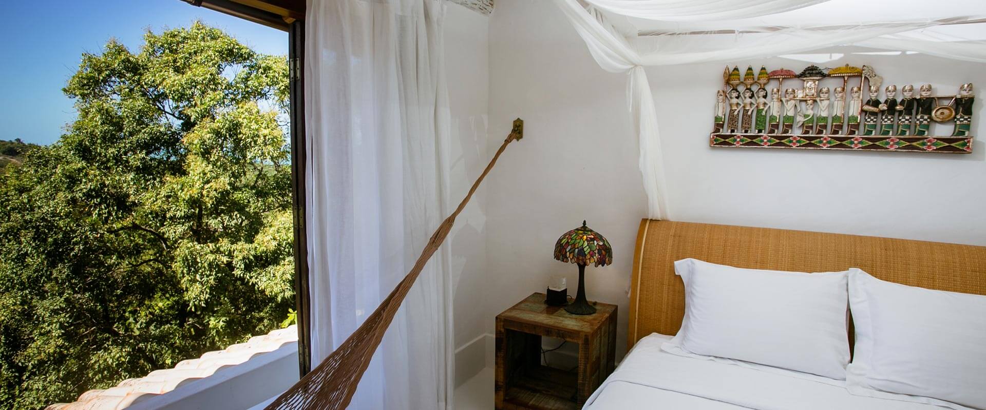 Suíte Luxo com cama queen, rede e janela com vista para o vale do Rio Trancoso